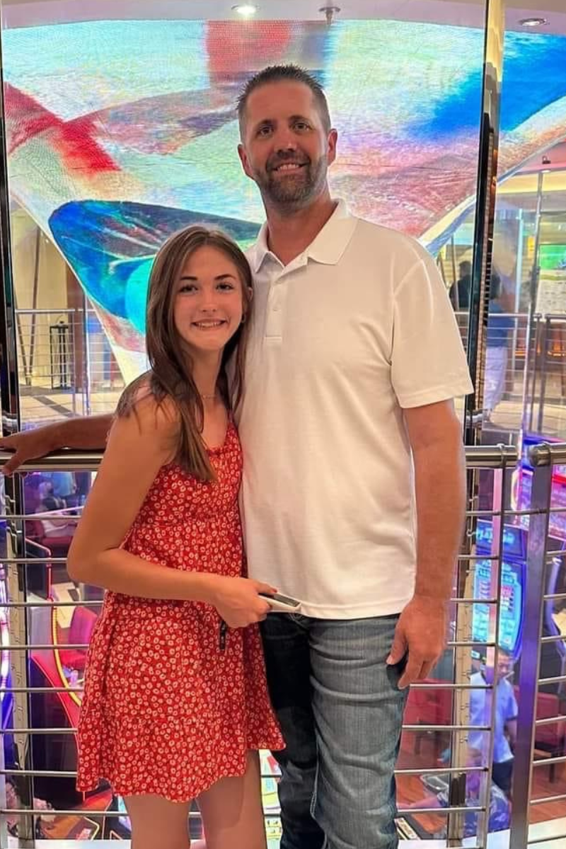 Jason Jordan owner of A/C Doctors stands posing with daughter on second level of a shopping mall.